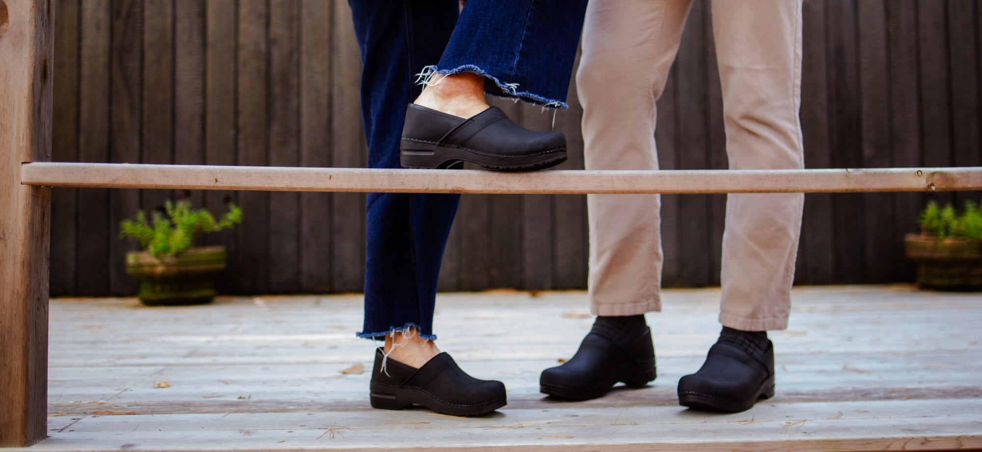 Two people wearing the Pro Oiled in Black stand together on a deck